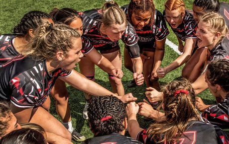 photo of the Brown women's Rugby Team huddling during a game